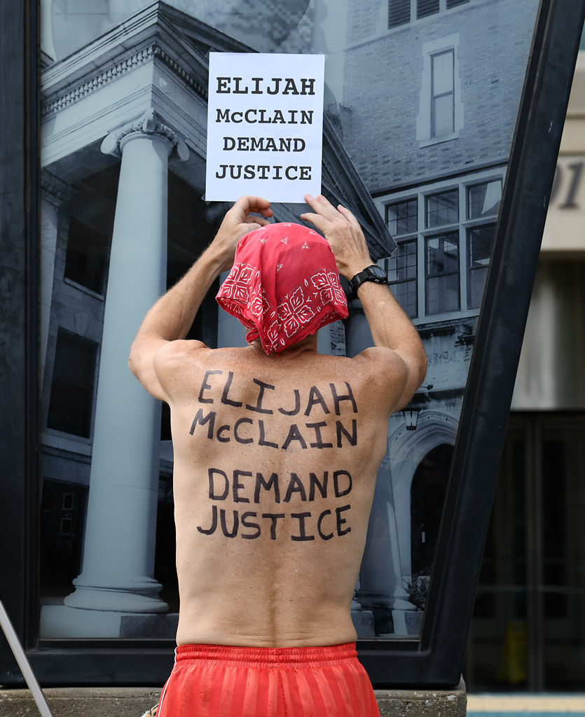 Derrick Fogle carries a message demanding justice for Elijah McClain on his back as he prepares to play hacky sack on Sunday